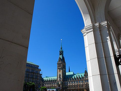 Foto Blick durch die Bögen der Alster Arkaden auf das Rathaus